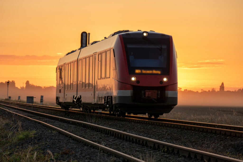 Small Railcar driving through the countryside in a beautiful sunrise